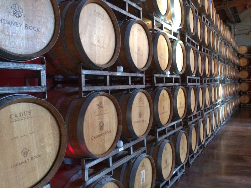 Botellas de vidrio oscuro sobre una mesa de madera en un ambiente cálido